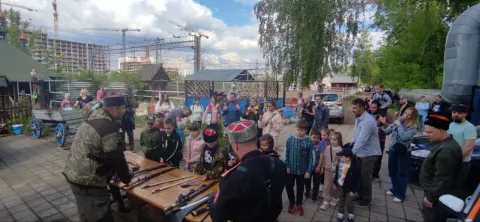 Казаки показывают детям оружие во дворе